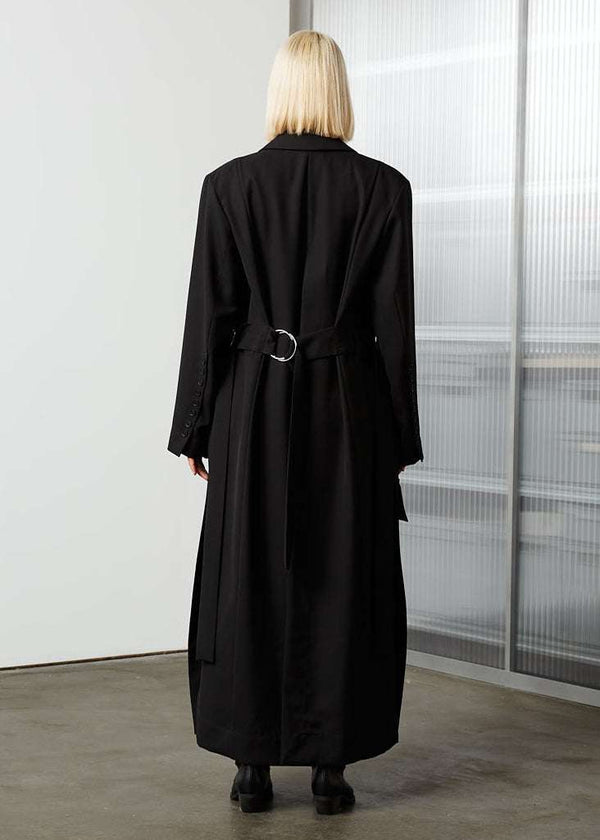 INTERNATIONAL CITIZEN.  Style: The M23 Duster Coat is double breasted with button closures, and features high slits at the sides and back. Unisex Item. Full back photo. Made of Italian Wool RWS, Obsidian Black. Spiritually Infused, Sustainable Luxury Fashion in Berlin.
