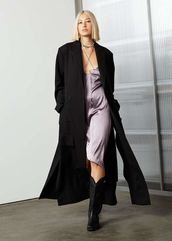 INTERNATIONAL CITIZEN.  Style: The M23 Duster Coat. Unisex Item. Walking photo. Made of Italian Wool RWS, Obsidian Black. Spiritually Infused, Sustainable Luxury Fashion in Berlin.