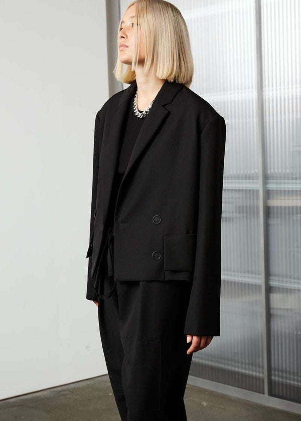 INTERNATIONAL CITIZEN.  Style: The Oversized Men’s Jacket features classic mens tailoring details within the inner construction with an oversized shape. Unisex item. Made of Italian Wool RWS, Obsidian Black. Spiritually Infused, Sustainable Luxury Fashion in Berlin. Side front view.
