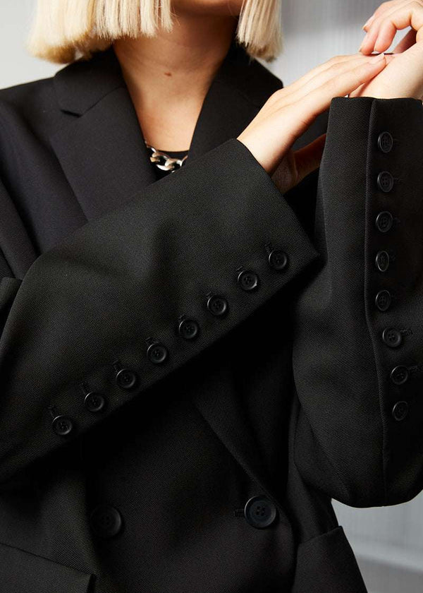 INTERNATIONAL CITIZEN.  Style: The Oversized Men’s Jacket features classic mens tailoring. Unisex item. Made of Italian Wool RWS, Obsidian Black. Spiritually Infused, Sustainable Luxury Fashion in Berlin. Close up sleeve photo.