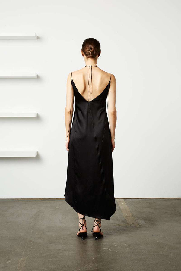 INTERNATIONAL CITIZEN.  Style: The Crystalline Dress. 
Black satin slip dress with back V-neck and thin straps.
Made of Organic Silk, Obsidian Black. Spiritually Infused, Sustainable Luxury Fashion in Berlin.