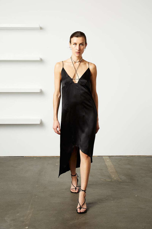 INTERNATIONAL CITIZEN.  Style: The Crystalline Dress. 
Black silk slip dress with thin straps and front slit, worn with layered jewelry.
Made of Organic Silk, Obsidian Black. Spiritually Infused, Sustainable Luxury Fashion in Berlin.