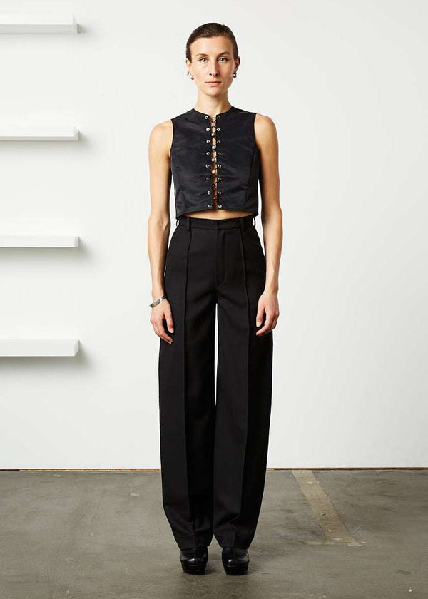 INTERNATIONAL CITIZEN.  Style: The Ribcage Trouser is a high waisted pant, with a perfectly tapered pin-tuck leg that falls over the shoe, featuring denim style detailing in the back body. Made of Italian Wool RWS, Obsidian Black. Spiritually Infused, Sustainable Luxury Fashion in Berlin. Full front photo.