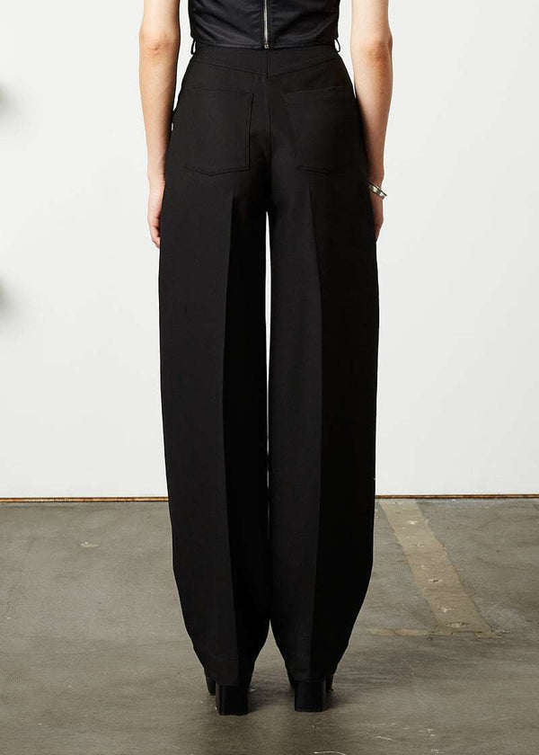 INTERNATIONAL CITIZEN.  Style: The Ribcage Trouser is a high waisted pant, with a perfectly tapered pin-tuck leg that falls over the shoe, featuring denim style detailing in the back body. Made of Italian Wool RWS, Obsidian Black. Spiritually Infused, Sustainable Luxury Fashion in Berlin. Close up back photo.