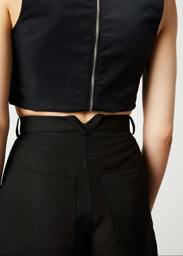 INTERNATIONAL CITIZEN.  Style: The Ribcage Trouser is a high waisted pant, with a perfectly tapered pin-tuck leg that falls over the shoe, featuring denim style detailing in the back body. Made of Italian Wool RWS, Obsidian Black. Spiritually Infused, Sustainable Luxury Fashion in Berlin. Close up back body.