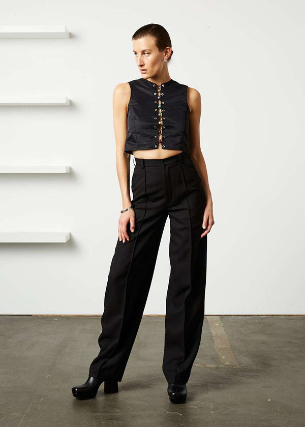 INTERNATIONAL CITIZEN.  Style: The Seven Chakra Top is an unlined shell top with an exposed silver metal zipper closure at the back. It features metal eyelets down the front and chakra crystals looped with a braided cord. Made of Italian post-consumer recycled Nylon, Obsidian Black. Spiritually Infused, Sustainable Luxury Fashion in Berlin. Full front photo.