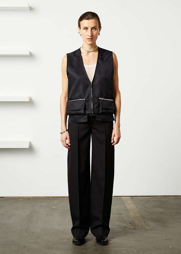 INTERNATIONAL CITIZEN.  Style: The Zipper Vest has double pocket detailing with both a patch pocket flat and zipper welt with exposed pocket bags. Unisex Item.. Made of Italian post consumer recycled Nylon, Obsidian Black. Spiritually Infused, Sustainable Luxury Fashion in Berlin. Full body front photo.
