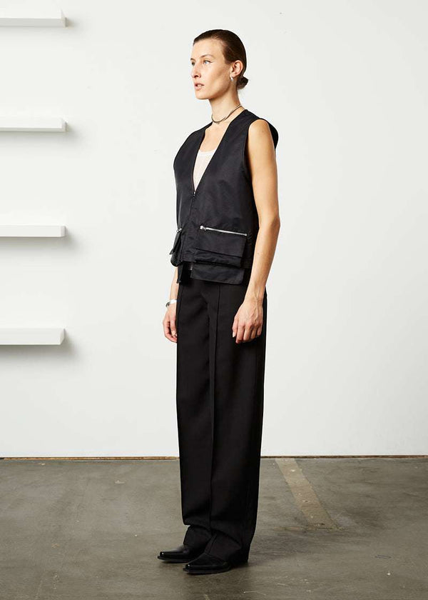 INTERNATIONAL CITIZEN.  Style: The Zipper Vest has double pocket detailing with both a patch pocket flat and zipper welt with exposed pocket bags. Unisex Item.. Made of Italian post consumer recycled Nylon, Obsidian Black. Spiritually Infused, Sustainable Luxury Fashion in Berlin. Full side front photo.