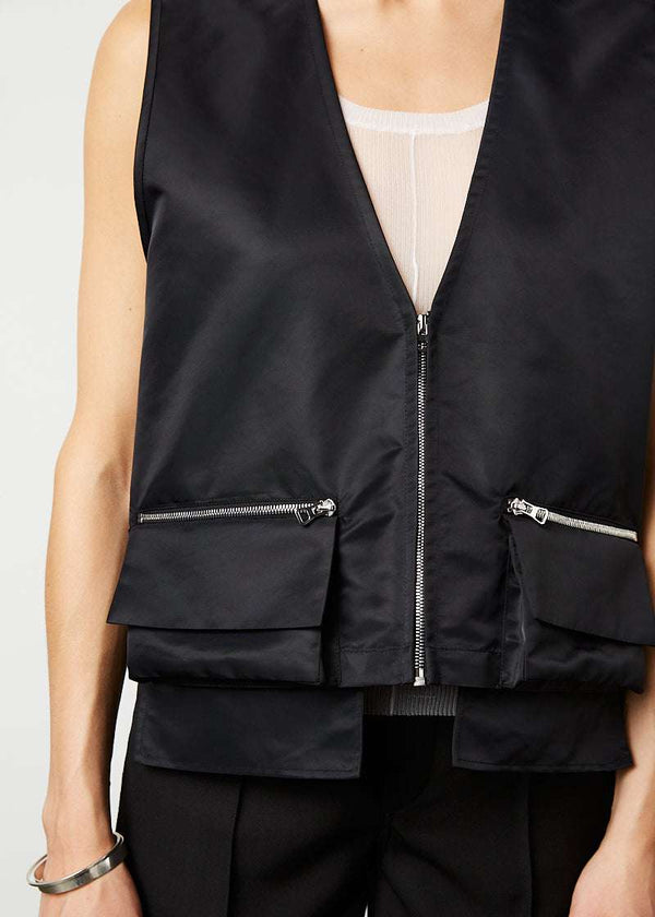 INTERNATIONAL CITIZEN.  Style: The Zipper Vest is water repellent and has double pocket detailing with both a patch pocket flat and zipper welt with exposed pocket bags. Unisex Item.. Made of Italian post consumer recycled Nylon, Obsidian Black. Spiritually Infused, Sustainable Luxury Fashion in Berlin. Close up front photo.