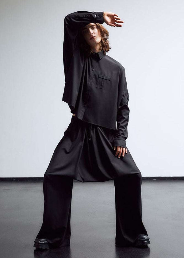 INTERNATIONAL CITIZEN.  Style: The Cubism Shirt is a 3-dimensional cube tilted on its axes to create a boxy minimal front body. Unisex Item. Full body front view. Made of Italian RWS Wool, Obsidian Black. Spiritually Infused, Sustainable Luxury Fashion in Berlin.