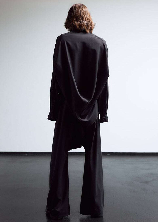 INTERNATIONAL CITIZEN.  Style: The Cubism Shirt is a 3-dimensional cube tilted on its axes to create a dramatic drape in the back body. Unisex Item. Full body back view. Made of Italian RWS Wool, Obsidian Black. Spiritually Infused, Sustainable Luxury Fashion in Berlin.