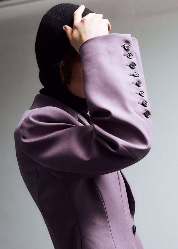 INTERNATIONAL CITIZEN.  Style: The Hourglass Jacket is named after its perfected silhouette, shaped with a nipped waist. It has welt flap pockets, brand iconic 8-button sleeve vent closure and oversized bent sleeve. Unisex Item. Close up of the sleeve. Made of Italian Wool, certified RWS, Amethyst Purple. Spiritually Infused, Sustainable Luxury Fashion in Berlin.