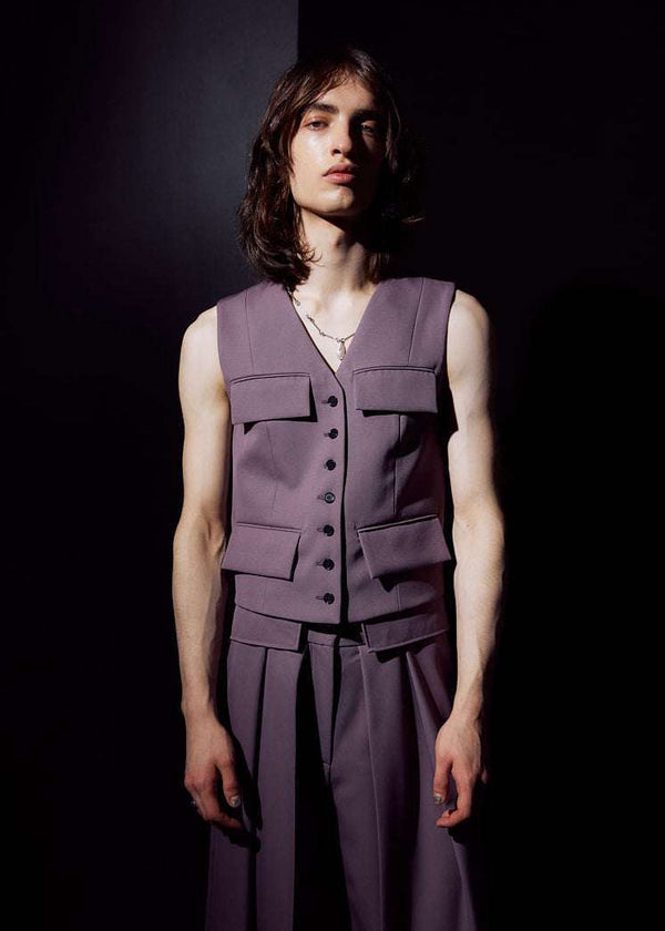 INTERNATIONAL CITIZEN.  Style: The Tarot Vest is a riff on classic vest detailing with exposed hem pocket bags and 7-Chakra button closure down the front. Made of Italian Wool RWS, Obsidian Black. Spiritually Infused, Sustainable Luxury Fashion in Berlin. Male front photo.