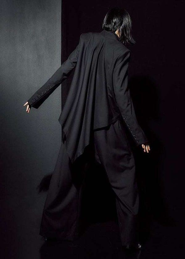 INTERNATIONAL CITIZEN.  Style: The Ascension Jacket. Back full body view. Style has a tailored structured front body, an asymmetrical cascading back body on the bias. The jacket is made of Italian RWS Wool in Obsidian Black. Spiritually Infused, Sustainable Luxury Fashion in Berlin.