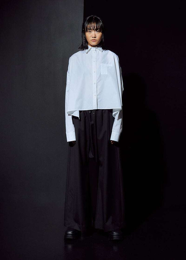 INTERNATIONAL CITIZEN.  Style: The Cubism Shirt is a 3-dimensional cube tilted on its axes to create a boxy minimal front body and dramatic drape in the back body. Unisex Item. Full body front view. Made of Italian Organic Cotton, White Quartz. Spiritually Infused, Sustainable Luxury Fashion in Berlin.