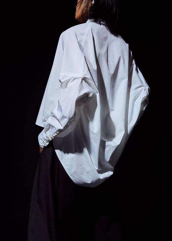 INTERNATIONAL CITIZEN.  Style: The Cubism Shirt is a 3-dimensional cube tilted on its axes to create a boxy minimal front body and dramatic drape in the back body. Unisex Item.  Side back view. Made of Italian Organic Cotton, White Quartz. Spiritually Infused, Sustainable Luxury Fashion in Berlin.