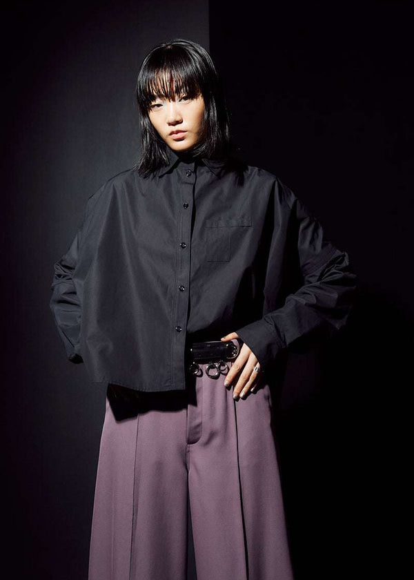 INTERNATIONAL CITIZEN.  Style: The Cubism Shirt is a 3-dimensional cube tilted on its axes to create a boxy minimal front body and a utility pen pocket on the chest. Unisex Item. Front photo. Made of Italian Organic Cotton, Obsidian Black. Spiritually Infused, Sustainable Luxury Fashion in Berlin.