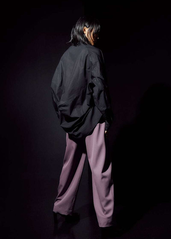 INTERNATIONAL CITIZEN.  Style: The Cubism Shirt is a 3-dimensional cube tilted on its axes to create a boxy minimal front body and dramatic drape in the back body. Unisex Item. Full body back view. Made of Italian Organic Cotton, Obsidian Black. Spiritually Infused, Sustainable Luxury Fashion in Berlin.