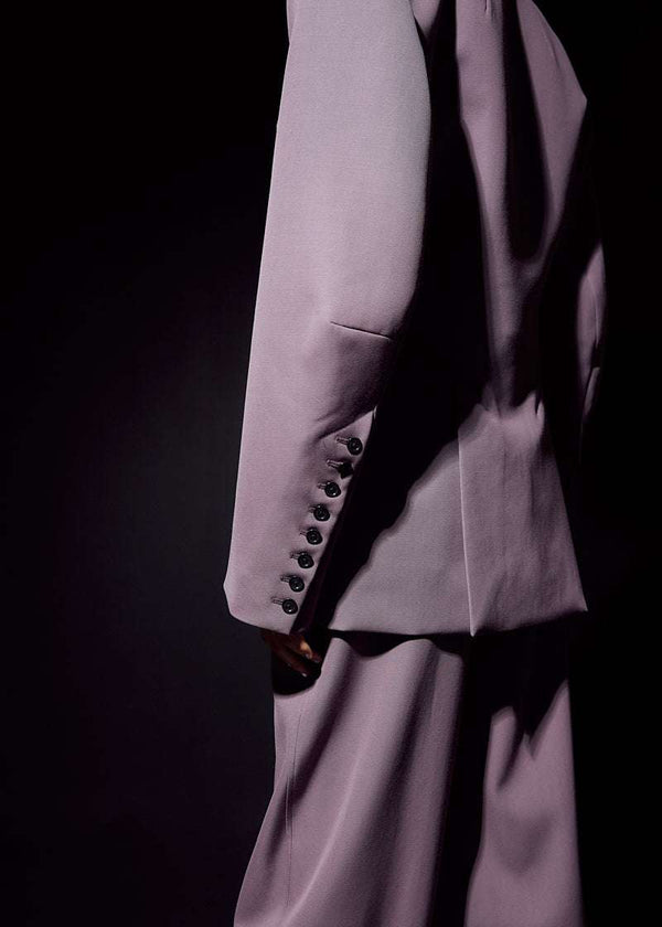 INTERNATIONAL CITIZEN.  Style: The Hourglass Jacket is named after its perfected silhouette, shaped with a nipped waist. It has welt flap pockets, brand iconic 8-button sleeve vent closure and oversized bent sleeve. Unisex Item. Close up pf the sleeve. Made of Italian Wool, certified RWS, Amethyst Purple. Spiritually Infused, Sustainable Luxury Fashion in Berlin.