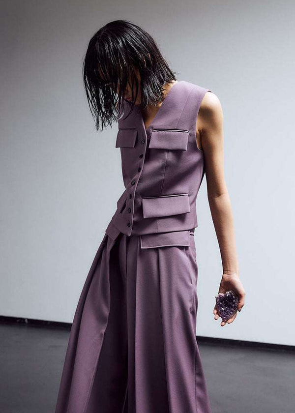 INTERNATIONAL CITIZEN.  Style: The Tarot Vest is a riff on classic vest detailing with exposed hem pocket bags and 7-Chakra button closure down the front. Made of Italian Wool RWS, Obsidian Black. Spiritually Infused, Sustainable Luxury Fashion in Berlin. Side front photo.