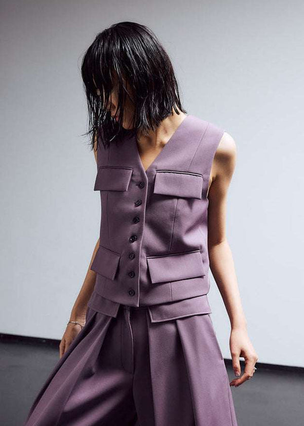INTERNATIONAL CITIZEN.  Style: The Tarot Vest is a riff on classic vest detailing with exposed hem pocket bags and 7-Chakra button closure down the front. Made of Italian Wool RWS, Obsidian Black. Spiritually Infused, Sustainable Luxury Fashion in Berlin. Front photo.