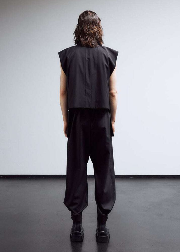 INTERNATIONAL CITIZEN.  Style: The JiuJitsu Pants have a straight leg with silver snap hem straps and a thigh patch. Unisex item. Full back male model photo. Made of Italian Wool, certified (RWS) Responsible Wool Standard, Obsidian Black. Spiritually Infused, Sustainable Luxury Fashion in Berlin.