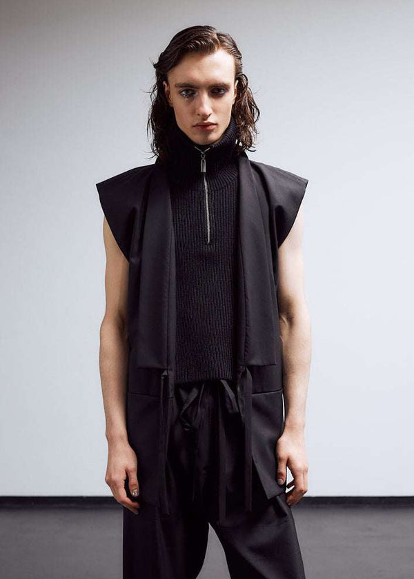 INTERNATIONAL CITIZEN.  Style: The Kimono Vest has a longer front body with inseam pockets. Unisex Item. Male front photo worn open. Made of Italian Wool, certified (RWS) Responsible Wool Standard, Obsidian Black. Spiritually Infused, Sustainable Luxury Fashion in Berlin.
