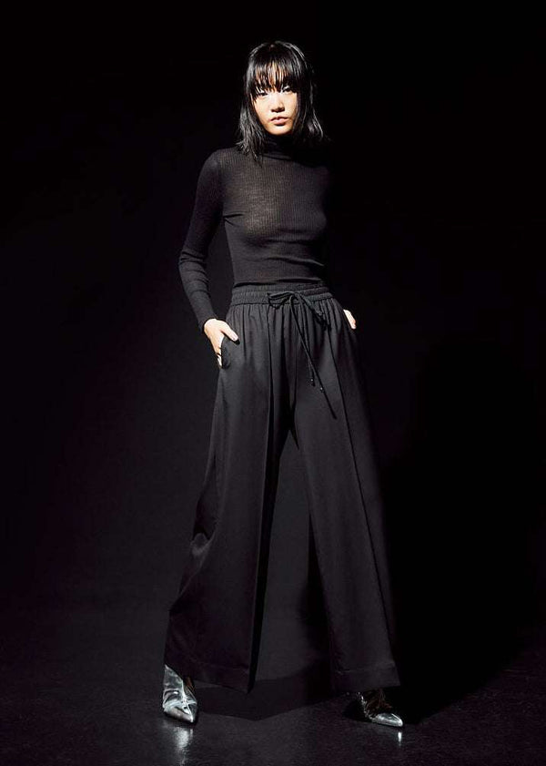 INTERNATIONAL CITIZEN.  Style: The Arcana Pant. Style has a relaxed fit with front pin-tucks and excessive volume eased into the waistband. Unisex Item. The pants are made of Italian RWS Wool in Obsidian Black. Spiritually Infused, Sustainable Luxury Fashion in Berlin.