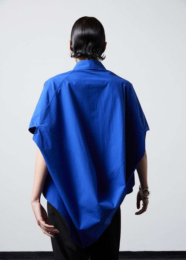 INTERNATIONAL CITIZEN.  Style: The Cubism Shirt is a 3-dimensional cube tilted on its axes to create a dramatic drape in the back body. Unisex Item. Cropped back body. Made of Italian Organic Cotton, Lapis Lazuli Blue. Spiritually Infused, Sustainable Luxury Fashion in Berlin.