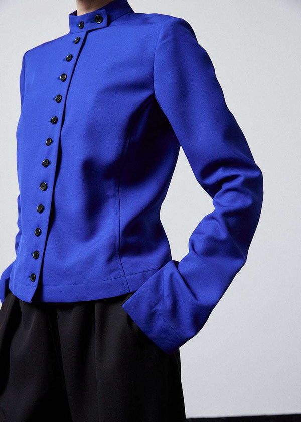 INTERNATIONAL CITIZEN.  Style: The Lunar Shacket is a slim jacket that wears like a shirt. It is lined with horn buttons down the front closure and sleeve vent. It has a bias under sleeve for a slim fit. Close up front photo. Made of Italian Wool RWS, Lapis Lazuli Blue. Spiritually Infused, Sustainable Luxury Fashion in Berlin.