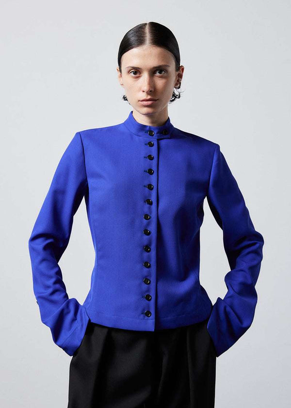 INTERNATIONAL CITIZEN.  Style: The Lunar Shacket is a slim jacket that wears like a shirt. It is lined with horn buttons down the front closure and sleeve vent. Cropped front photo. Made of Italian Wool RWS, Lapis Lazuli Blue. Spiritually Infused, Sustainable Luxury Fashion in Berlin.