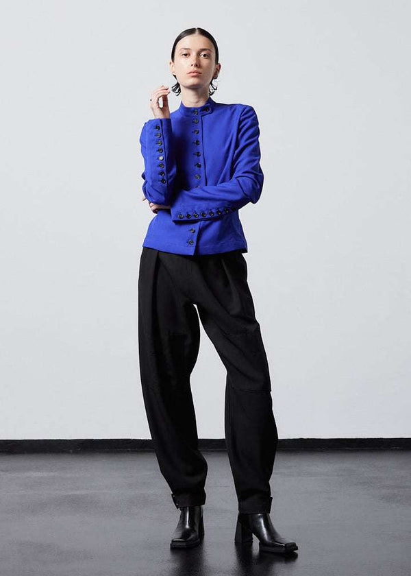 INTERNATIONAL CITIZEN.  Style: The Lunar Shacket is a slim jacket that wears like a shirt. It is lined with horn buttons down the front closure and sleeve vent. It has a bias under sleeve for a slim fit, extra-long sleeves, and an elastic back waist. Full front view. Made of Italian Wool RWS, Lapis Lazuli Blue. Spiritually Infused, Sustainable Luxury Fashion in Berlin.