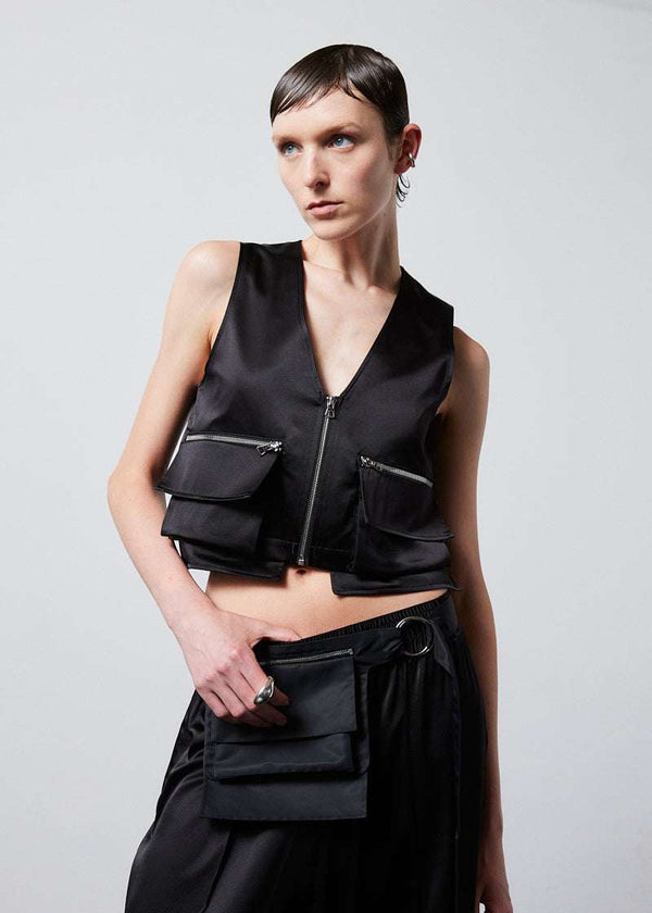 INTERNATIONAL CITIZEN.  Style: The Mini Zipper Vest has double pocket detailing with both a patch pocket and zipper welt with exposed pocket bags. It is fully lined with cotton poplin. Made of Organic Silk, Obsidian Black. Spiritually Infused, Sustainable Luxury Fashion in Berlin. Front view.