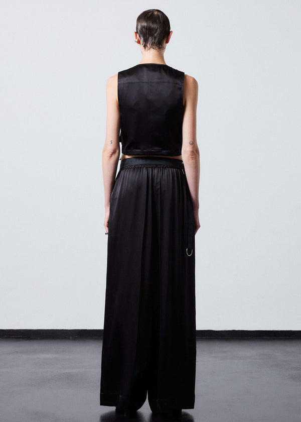 INTERNATIONAL CITIZEN.  Style: The Arcana Pant. Back full body view. Style has a relaxed fit with front pin-tucks and excessive volume eased into the waistband. Unisex Item. The pants are made of Italian organic silk in Obsidian Black. Spiritually Infused, Sustainable Luxury Fashion in Berlin.