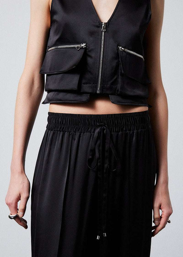 INTERNATIONAL CITIZEN.  Style: The Arcana Pant. Close up front photo. Style has a relaxed fit with front pin-tucks and excessive volume eased into the waistband. Unisex Item. The pants are made of Italian organic silk in Obsidian Black. Spiritually Infused, Sustainable Luxury Fashion in Berlin.