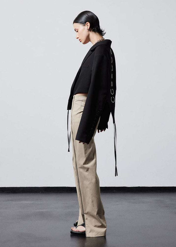 INTERNATIONAL CITIZEN.  Style: The French-Cut Jacket is oversized in the fit with a high french-cut hemline. Side profile photo. Unisex item. Made of Italian Wool, Obsidian Black. Spiritually Infused, Sustainable Luxury Fashion in Berlin.