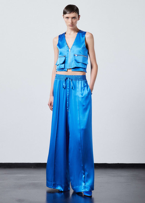 INTERNATIONAL CITIZEN.  Style: The Arcana Pant. Front full body photo. Style has a relaxed fit with front pin-tucks and excessive volume eased into the waistband. Unisex Item. The pants are made of Italian organic silk in Azurite Blue. Spiritually Infused, Sustainable Luxury Fashion in Berlin.
