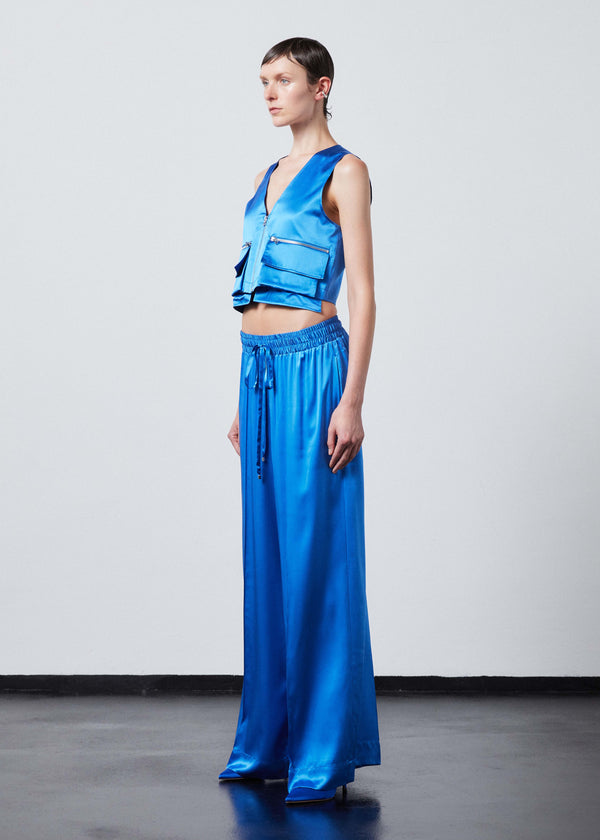 INTERNATIONAL CITIZEN.  Style: The Mini Zipper Vest has double pocket detailing with both a patch pocket and zipper welt with exposed pocket bags. Made of Organic Silk, Azurite Blue. Spiritually Infused, Sustainable Luxury Fashion in Berlin.
Side full front view. 