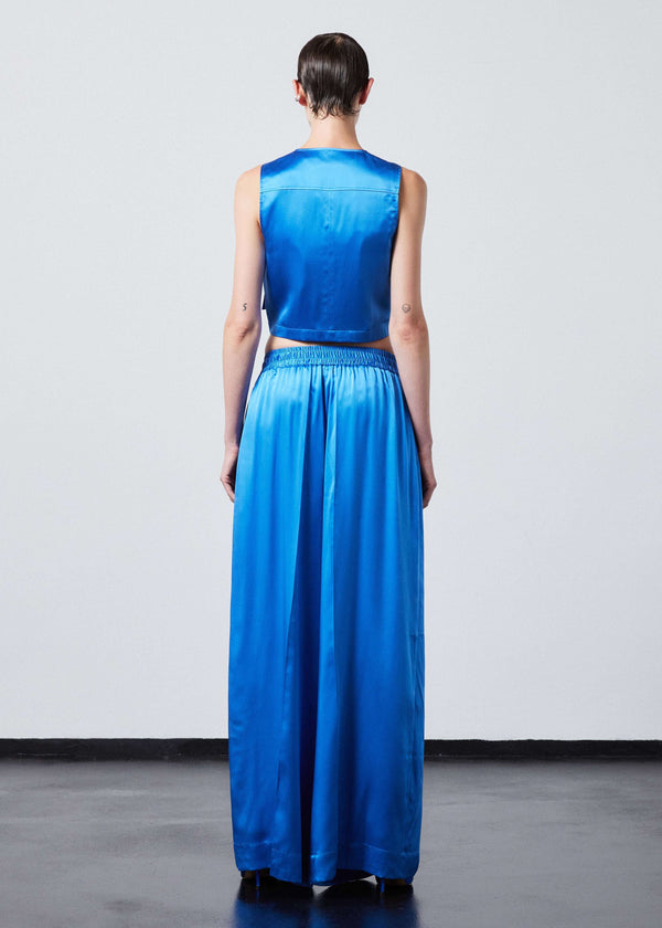 INTERNATIONAL CITIZEN.  Style: The Arcana Pant. Back full body view. Style has a relaxed fit with front pin-tucks and excessive volume eased into the waistband. Unisex Item. The pants are made of Italian organic silk in Azurite Blue. Spiritually Infused, Sustainable Luxury Fashion in Berlin.
