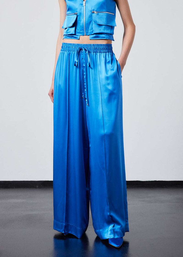 INTERNATIONAL CITIZEN.  Style: The Arcana Pant. Style has a relaxed fit with front pin-tucks and excessive volume eased into the waistband. Unisex Item. The pants are made of Italian organic silk in Azurite Blue. Spiritually Infused, Sustainable Luxury Fashion in Berlin.