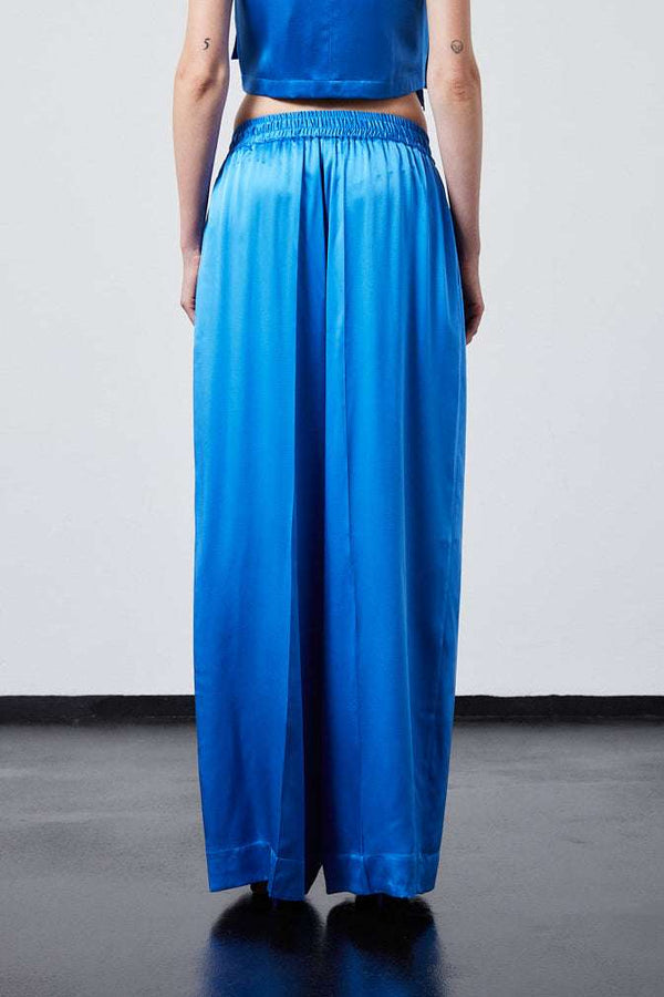 INTERNATIONAL CITIZEN.  Style: The Arcana Pant. Back close up view. Style has a relaxed fit with front pin-tucks and excessive volume eased into the waistband. Unisex Item. The pants are made of Italian organic silk in Azurite Blue. Spiritually Infused, Sustainable Luxury Fashion in Berlin.
