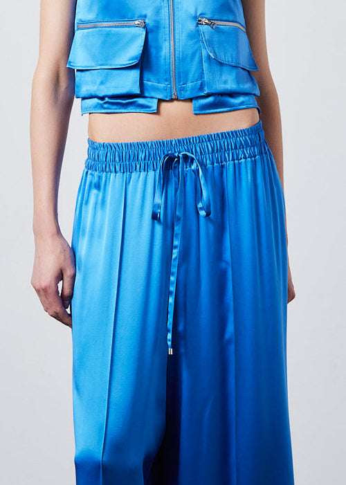 INTERNATIONAL CITIZEN.  Style: The Arcana Pant. Close up front photo. Style has a relaxed fit with front pin-tucks and excessive volume eased into the waistband. Unisex Item. The pants are made of Italian organic silk in Azurite Blue. Spiritually Infused, Sustainable Luxury Fashion in Berlin.