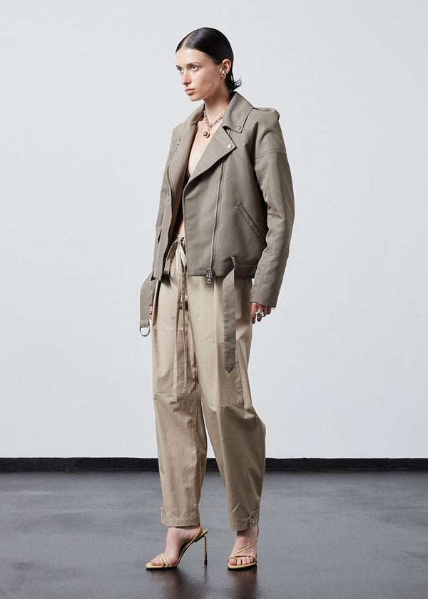 INTERNATIONAL CITIZEN.  Style: The M23 Moto Jacket has classic moto detailing and an innovative drape at the back shoulder creating a soft strength in the silhouette. Unisex Item. Side front view. Made of Italian post-consumer recycled Nylon, Dune. Spiritually Infused, Sustainable Luxury Fashion in Berlin.