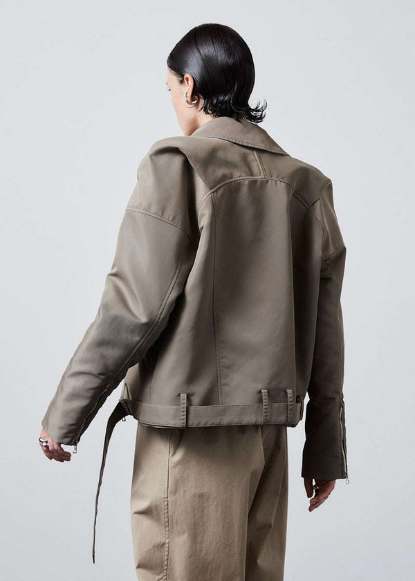 INTERNATIONAL CITIZEN.  Style: The M23 Moto Jacket has classic moto detailing and an innovative drape at the back shoulder creating a soft strength in the silhouette. Unisex Item. Side back view. Made of Italian post-consumer recycled Nylon, Dune. Spiritually Infused, Sustainable Luxury Fashion in Berlin.