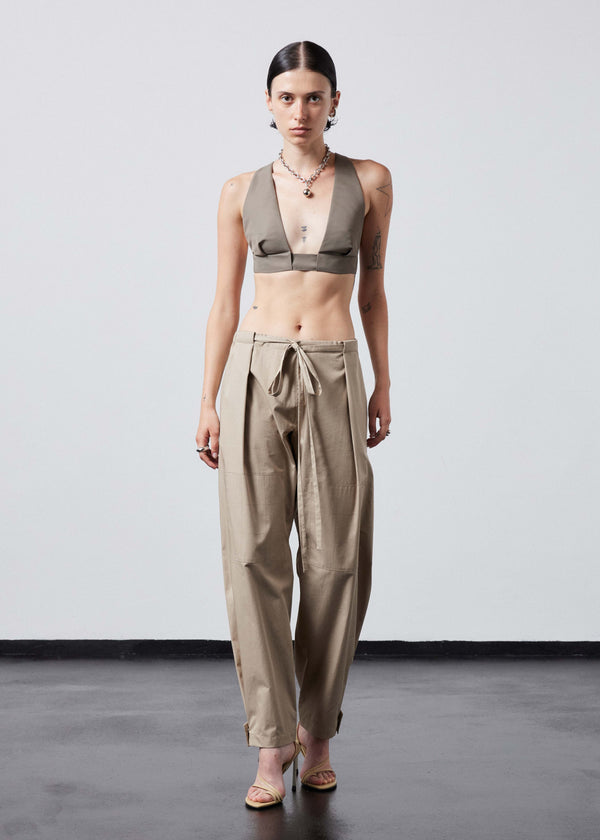 INTERNATIONAL CITIZEN.  Style: The JiuJitsu Pants are have a drawstring closer at the waist, a straight leg with silver snap hem straps and a thigh patch. Unisex item. Full body front photo. Made of Italian Organic Cotton Twill, Dune. Spiritually Infused, Sustainable Luxury Fashion in Berlin.