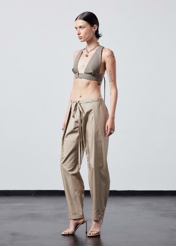 INTERNATIONAL CITIZEN.  Style: The JiuJitsu Pants are have a drawstring closer at the waist, a straight leg with silver snap hem straps and a thigh patch. Unisex item. Full 3/4 front photo. Made of Italian Organic Cotton Twill, Dune. Spiritually Infused, Sustainable Luxury Fashion in Berlin.
