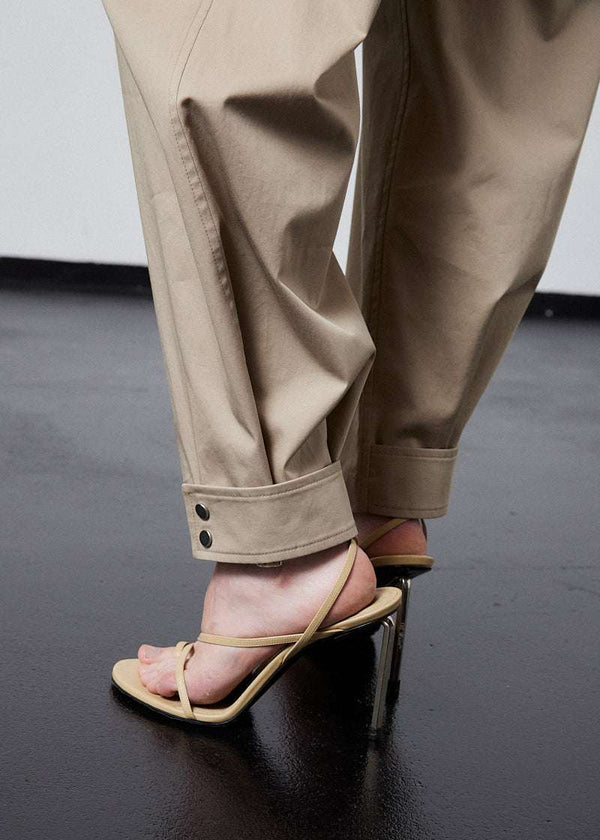 INTERNATIONAL CITIZEN.  Style: The JiuJitsu Pants feature silver snap hem straps and a thigh patch. Unisex item. Close up leg photo. Made of Italian Organic Cotton Twill, Dune. Spiritually Infused, Sustainable Luxury Fashion in Berlin.
