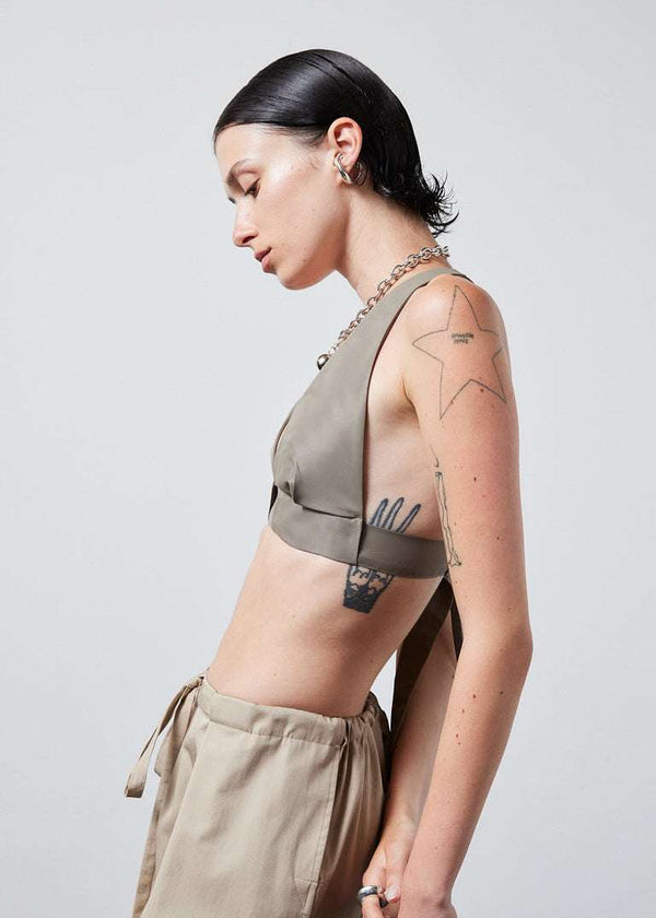 INTERNATIONAL CITIZEN.  Style: The Lunar Bralette features adjustable shoulder and chest straps with silver rings. Side profile view. Made of Italian post-consumer recycled Nylon, Dune. Spiritually Infused, Sustainable Luxury Fashion in Berlin.