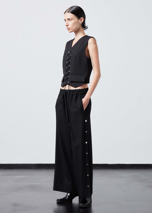 INTERNATIONAL CITIZEN.  Style: The Stitch Vest. Made of Italian Wool RWS, Obsidian Black. Spiritually Infused, Sustainable Luxury Fashion in Berlin. Full body side front photo.