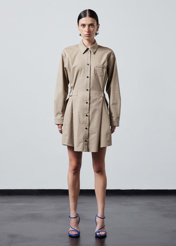 INTERNATIONAL CITIZEN.  Style: Artist Shirt Dress. Front full body view. Style has an oversized shirt with a pen pocket at the chest, open underarms for breathability, and back belt ties that adjust at the front with silver rings. The shirt are made of Italian organic Cotton Twill in Dune. Spiritually Infused, Sustainable Luxury Fashion in Berlin.